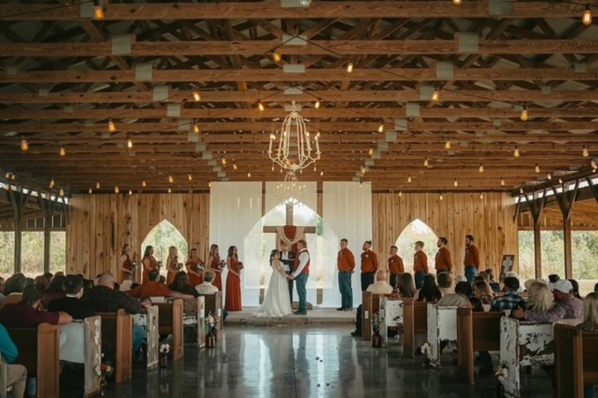 Couple saying their vows inside the Tobacco Barn at Burdoc Farms.