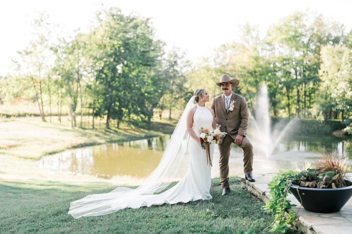 Couple at an outdoor wedding standing in front of a pond at Burdoc Farms.